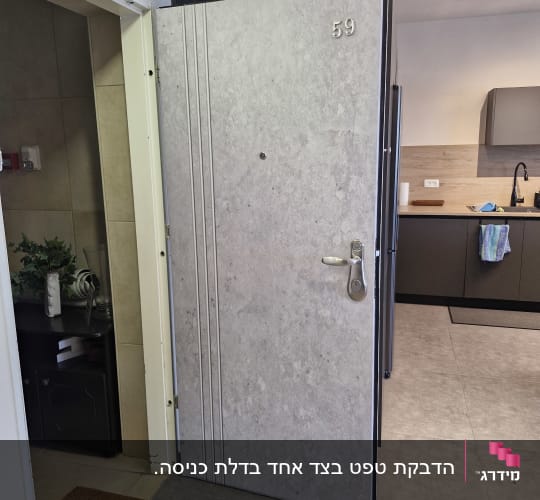 דלת כניסה לדירה מחופה בציפוי דמוי בטון בהיר עם חריצים דקורטיביים